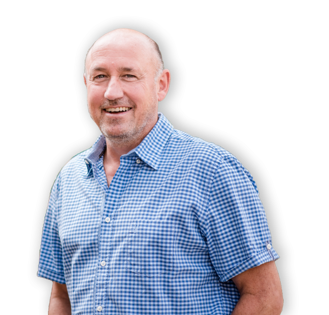 Manfred Wagner lächelt freundlich in die Kamera. Er trägt ein karriertes Hemd und hat kurzes, graues Haar und einen Dreitagebart