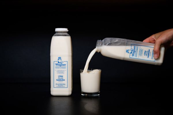 Eine Flasche Kuhmilch und ei Glas mit frischer Kuhmilch und ein Glas mit Kaba